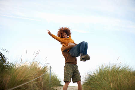Couple playing on grassy dune