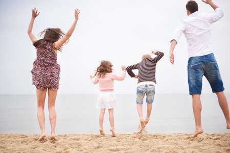 Family jumping on beachの写真素材