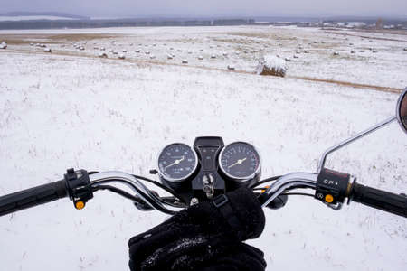 Motorbike parked on snow covered fieldの写真素材