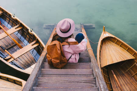 Woman relaxing on pier, Lago di Braies, Dolomite Alps, Val di Braies, South Tyrol, Italyの写真素材