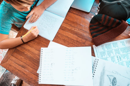 Overhead view of boy (10-11) doing homework at tableの写真素材