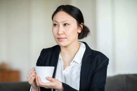 Businesswoman with coffee cup in officeの写真素材