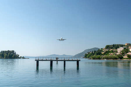 Greece, Corfu island, Airplane flying above seaのeditorial素材