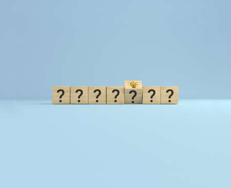 Concept creative idea and innovation. Flip over wooden cube block with question sign and light bulb...