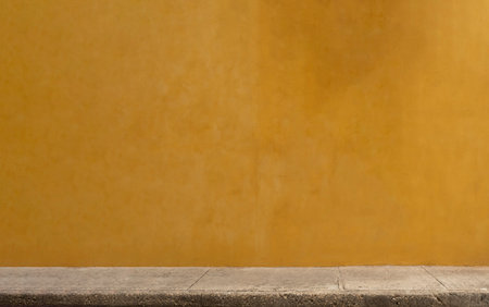 Colorful yellow wall of caribbean house with stucco texture for background. Minimal exterior space.の写真素材