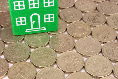 A green home on a bed of coinsの写真素材