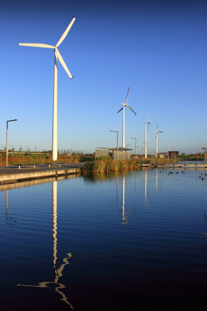 Wind turbines reflected in a parkland water way 