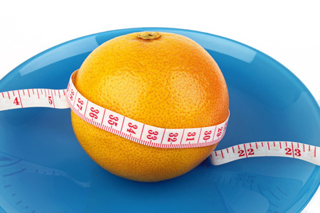 a grapefruit with a measure tape wrapped around it の写真素材