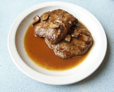 Large steak with juices on white plateの写真素材