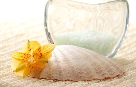 Bath salt, seashell and flowers on towelの写真素材