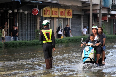 BANGKOK, THAILAND - NOVEMBER 17 : Motorbike navigates the floods after the heaviest rains in 20 years in Thailand on Nov 17, 2011 in Bangkok, Thailandのeditorial素材