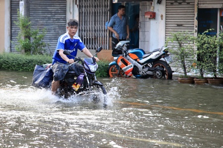BANGKOK, THAILAND - NOVEMBER 17 : Motorbike navigates the floods after the heaviest rains in 20 years in Thailand on Nov 17, 2011 in Bangkok, Thailandのeditorial素材