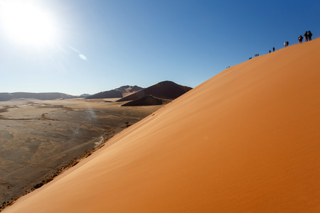 SOSSUSVLEI, NAMIBIA - NOVEMBER 2 2013: Tourists climb Dune No.45 in a year that was declared as a drought year by the government in Namibia, Africaのeditorial素材