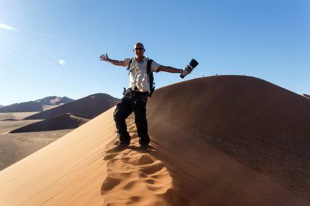 SOSSUSVLEI, NAMIBIA - NOVEMBER 2 2013: Tourists climb Dune No.45 in a year that was declared as a drought year by the government in Namibia, Africaのeditorial素材