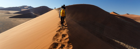 SOSSUSVLEI, NAMIBIA - NOVEMBER 2 2013: Tourists climb Dune No.45 in a year that was declared as a drought year by the government in Namibia, Africaのeditorial素材