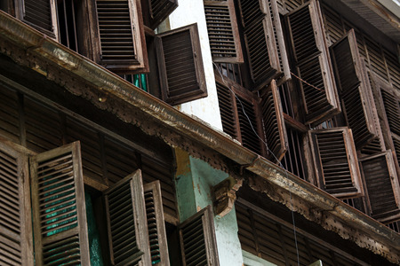 YANGON, MYANMAR - JUNE 12 2015: Rustic wooden window shutters open on one of the hottest recorded days before monsoon season in Yangon, Myanmar.のeditorial素材