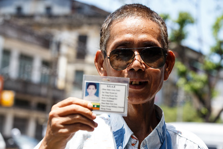 YANGON, MYANMAR - JUNE 12 2015: Military man holding id card on one of the hottest recorded days before monsoon season in Yangon, Myanmar.のeditorial素材