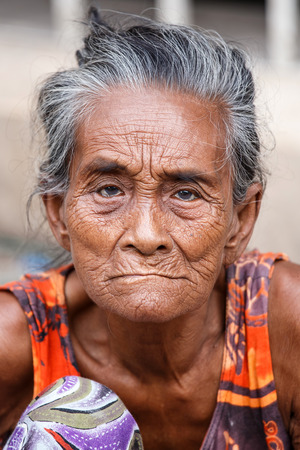 YANGON, MYANMAR - JUNE 12 2015: Older lady sits on the street on one of the hottest recorded days before monsoon season in Yangon, Myanmar.のeditorial素材