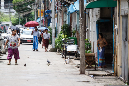 YANGON, MYANMAR - JUNE 12 2015: Local people walking on one of the hottest recorded days before monsoon season in Yangon, Myanmar.のeditorial素材