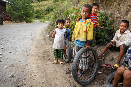 CHIN STATE, MYANMAR - JUNE 16 2015: Children play in the street of a village in the recently opened to foreigners area of Chin State - western Myanmar (Burma)のeditorial素材