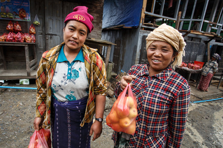 CHIN STATE, MYANMAR - JUNE 23 2015: Ladies selling apples in the recently opened to foreigners area of Chin State - western Myanmar (Burma)のeditorial素材