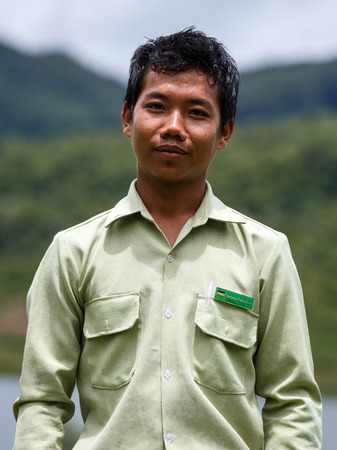 RHI, MYANMAR - JUNE 22 2015: Government Administration Official man wears smart green uniform in the recently opened region of Chin State in Western Myanmar (Burma)のeditorial素材