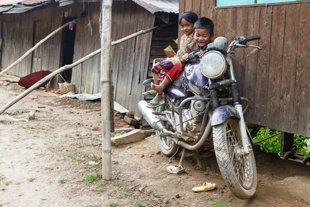FALAM, MYANMAR - JUNE 17 2015: Local children on motorbike in the recently opened to foreigners area of Chin State - western Myanmar (Burma)のeditorial素材
