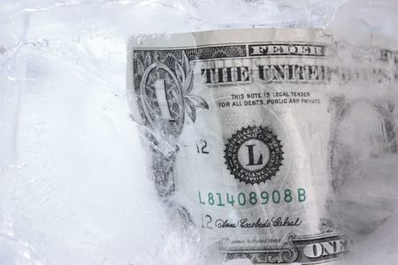 Frozen dollar in a block of iceの写真素材