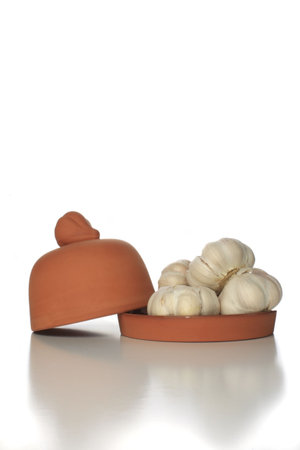 Garlic with ceramic cooker isolated on white backgroundの写真素材