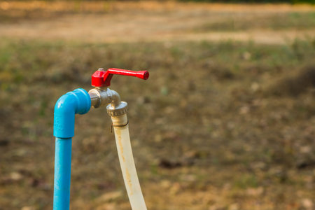 red faucet and blue PVC pipe with rubber tube