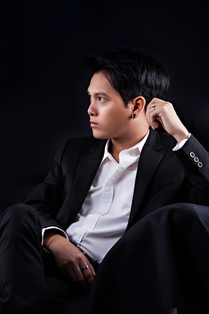 Portrait of Asian young man on black backgroundの写真素材