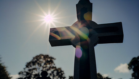 Cross on the cemetery with sunbeams in the background. Conceptual image.の素材