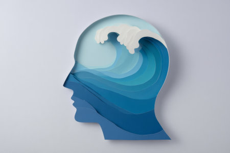 A papercraft human head silhouette filled with a calm, layered ocean wave. A powerful visual metaphor for mental health, calm, mindfulness, and psychology.の素材