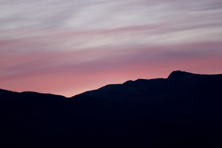 Beautiful pink evening sky. Hard black mountain contour in the foreground and the sky in the background.の写真素材