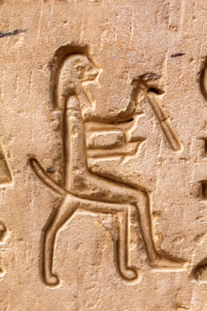 Carvings of a sitting man at the wall of a temple in Egyptの写真素材