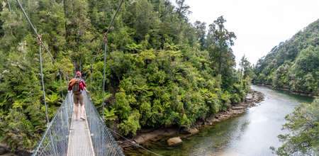Crossing a suspension footbridge at Abel Tasman Cost Trackの写真素材