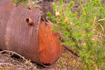 Old barrels rusting over decades in the grass of Waiuta ghost town, South Island of New Zealandの写真素材
