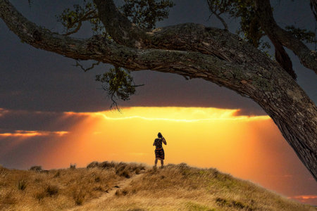A hiker standing on a hill, a scenic sky above herの写真素材