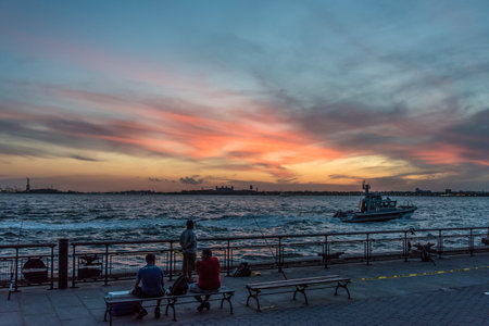 Sunset over the hudson river, Ellies Island and Statue of Liberty in the background, New York, USAの写真素材