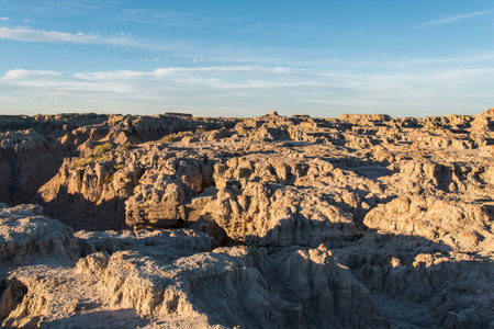 Jagged sandstone mountains illuminated by the sun in Badlands National Park, USAの写真素材