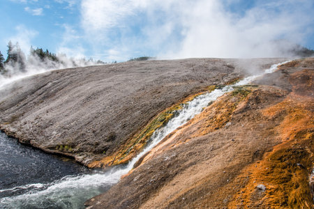 A little stream of hot water flowing in a natural pool, Yellowstone NP, USAの写真素材