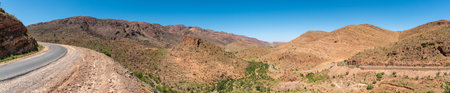 Great panoramic landscape of the Anti-Atlas mountains in the Taourirt region, a road winding through the mountains, Moroccoの写真素材
