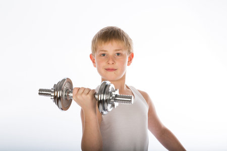 a young boy exercising with a dumbbellの写真素材