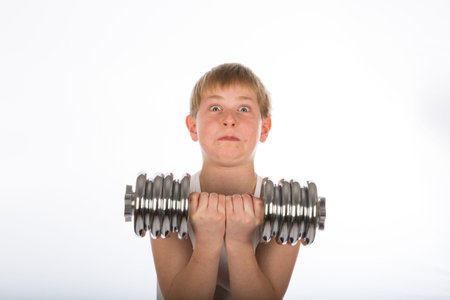 a young boy exercising with a dumbbellの写真素材