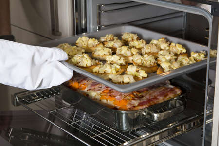a cook put crostinis and a casserole in the draw-plate baking ovenの写真素材