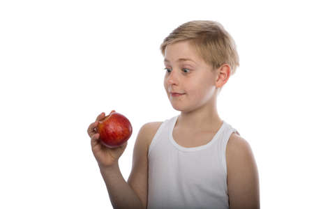 a young boy with a red apple isolated on white backgroundの写真素材