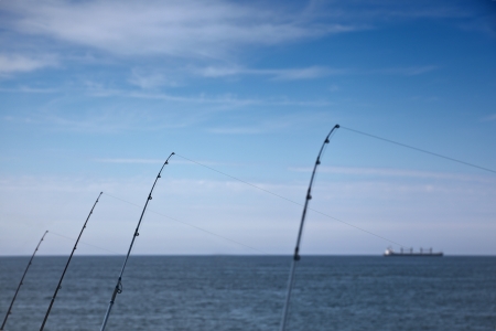 Four rods with a big ship in the blue horizonの写真素材