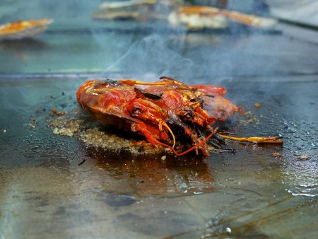 Two large King Prawns on the grill.  Large professional grill with a little olive oil and thick salt for cooking the prawns.の写真素材