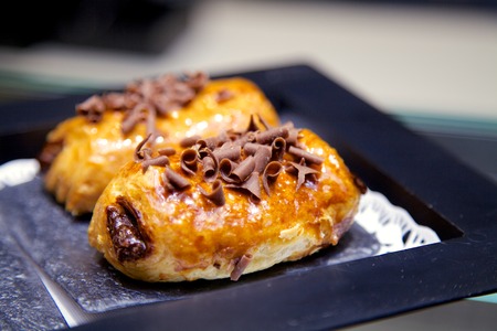 Pain au Chocolat on a Black Plate.  It is a traditional French Pastry known in Spanish as Napolitana de Chocolate.の写真素材