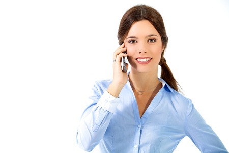 Close-up studio portrait of a businesswoman talking on the phone placed on the right of the frame; isolated on white.の写真素材